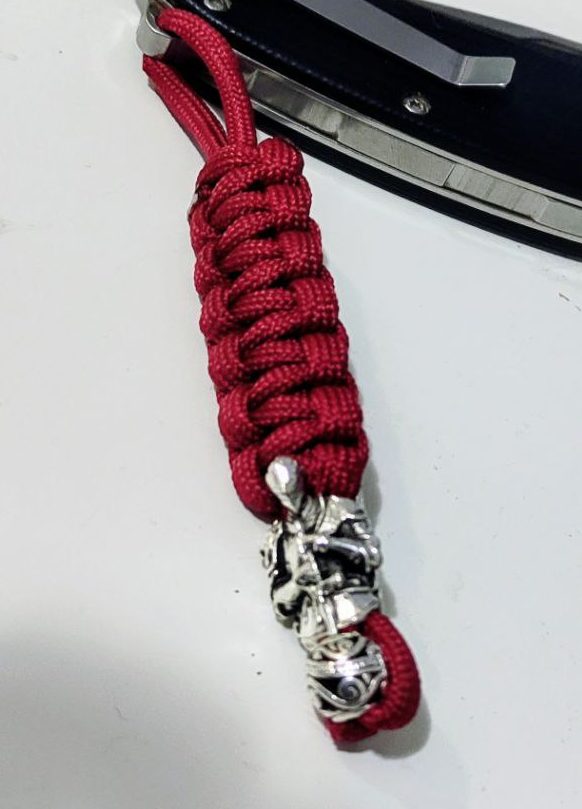 Folding knife with handmade red paracord braided lanyard – handcrafted EDC accessory from Choose.lv